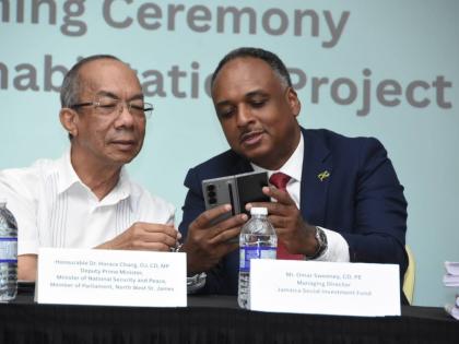 Deputy Prime Minister Dr Horace Chang (left) examines the proposed design for the Old Fort Craft Market in Montego Bay with Jamaica Social Investment Fund Managing Director Omar Sweeney.