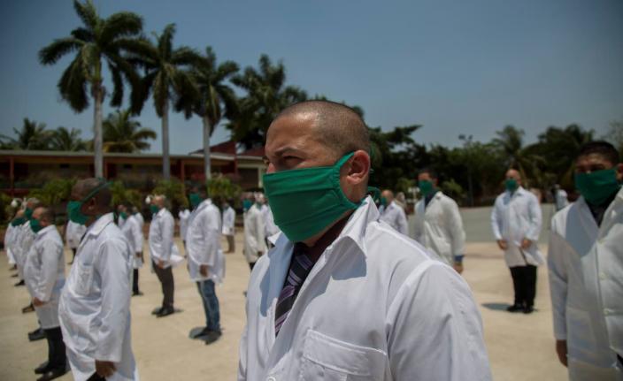Doctors form up during a farewell ceremony as they get ready to leave for Italy to help with the new coronavirus pandemic, in Havana, Cuba, in April 2020.