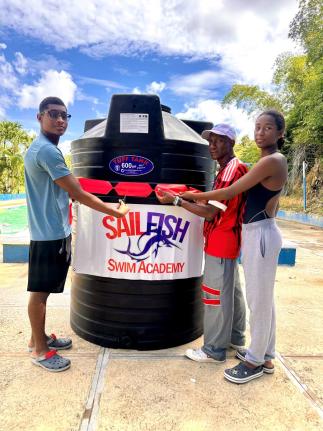 From left:  Suraj Guwalani, coach Eric Raul Urdaneta, and Shreya Guwalani during a ribbon-cutting ceremony for the presentation of a 600-gallon  tank to the SailFish Swim Academy in Tucker, St James, on Saturday, March 28.