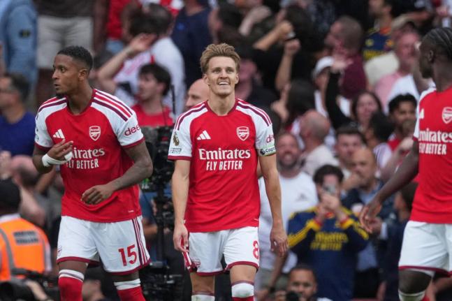 Arsenal’s Martin Odegaard (centre) reacts after scoring the winner during the English Premier League match between Arsenal and Chelsea in London yesterday.