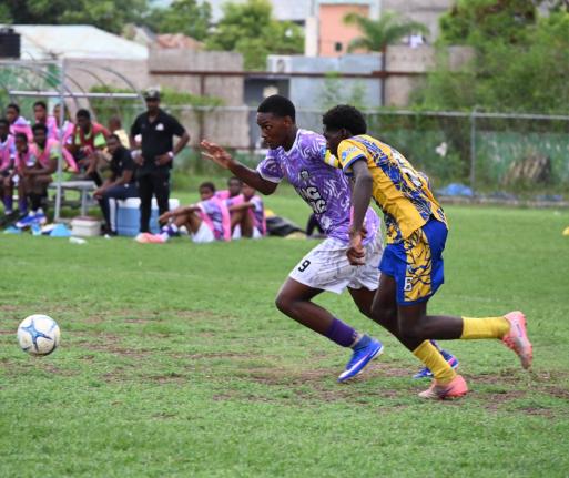 Irwin High’s Nathaniel Foster (left) and Cambridge High’s Dushaun Thomas go in chase of the ball during their ISSA daCosta Cup preliminary round game at Jarrett Park yesterday.
